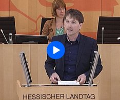 Jan Schalauske steht am hellbraunen Redner*innenpult im Hessischen Landtag und hält eine Rede.