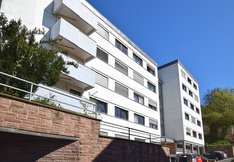 Blick auf das strahlend weiße Studentenwohnheim Konrad-Biesalski-Haus vor blauem Frühlingshimmel in Marburg